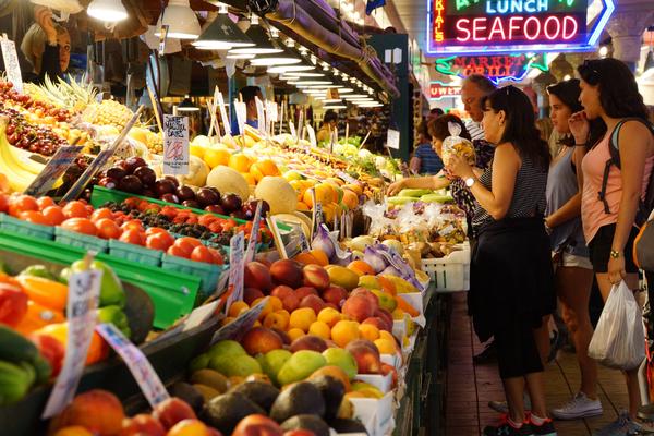 young women buy fresh fruit at the pike place market young women buy fresh fruit at the pike place market